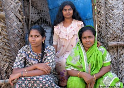 3 Tamil women in home made from woven coconut plam